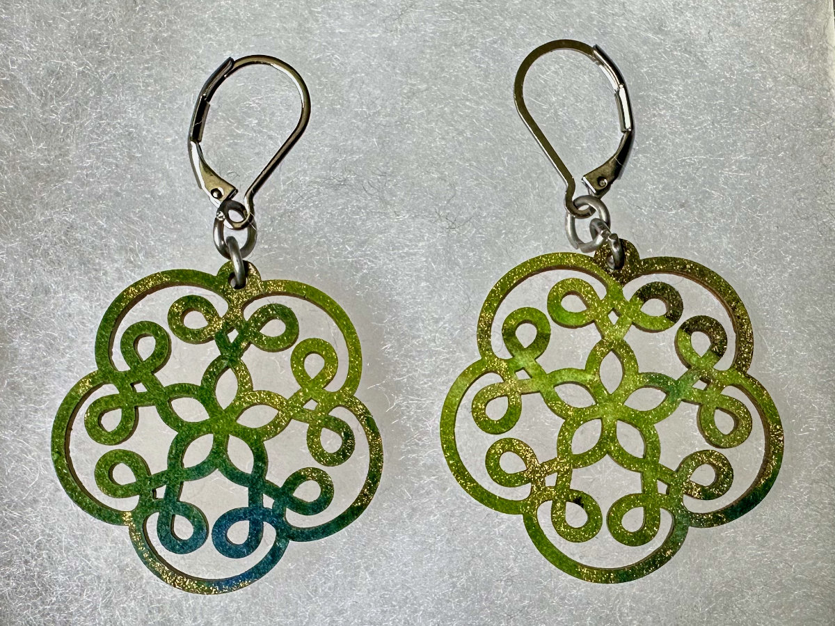 Laser cut wooden earings decorated with fancy paper.